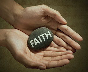 hands holding rock reading faith