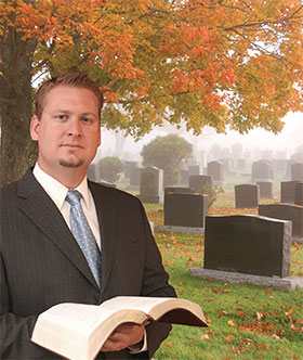 holding a Bible in the cemetary