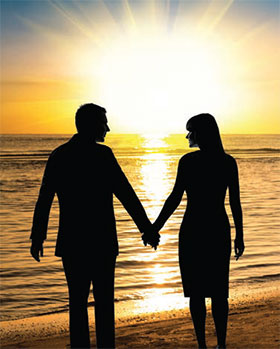man and woman on the beach at sunset