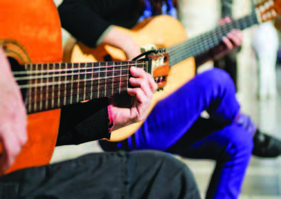 two people playing guitar