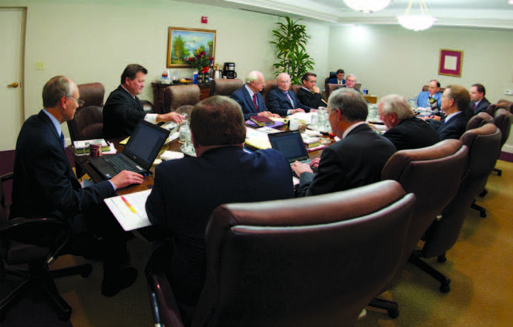 The Council of Elders seated around the conference table