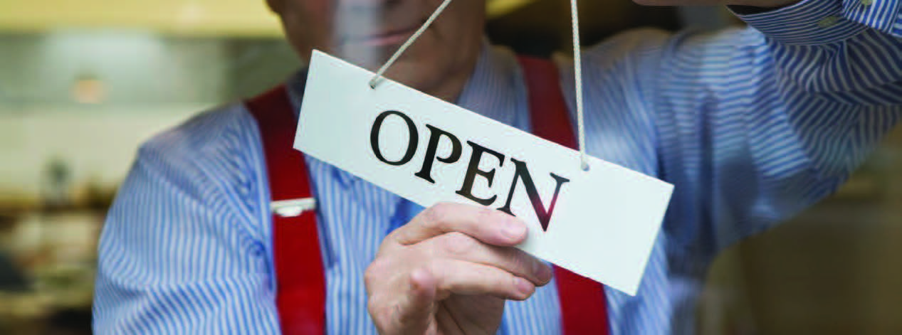 man turning open sign