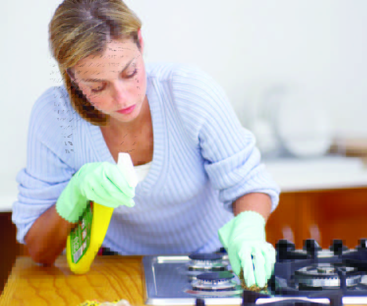 woman cleaning stove top